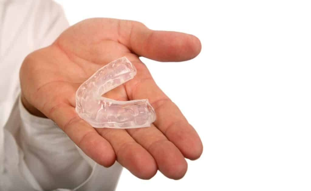 TMJ oral appliance being in held in palm of doctor’s hand