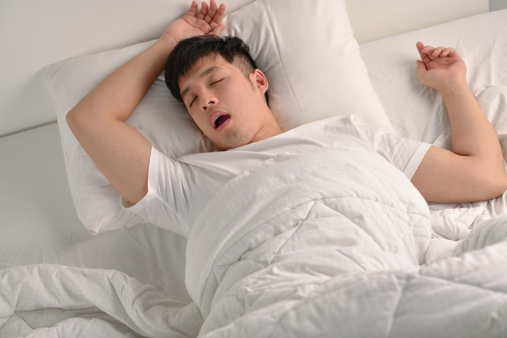 Young,Asian,Man,Sleeping,And,Snoring,Loudly,Lying,In,The